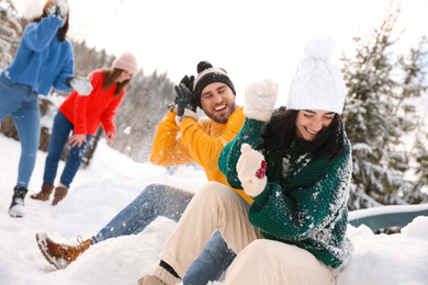 Photo of Group of friends playing snowballs outdoors. Winter vacation