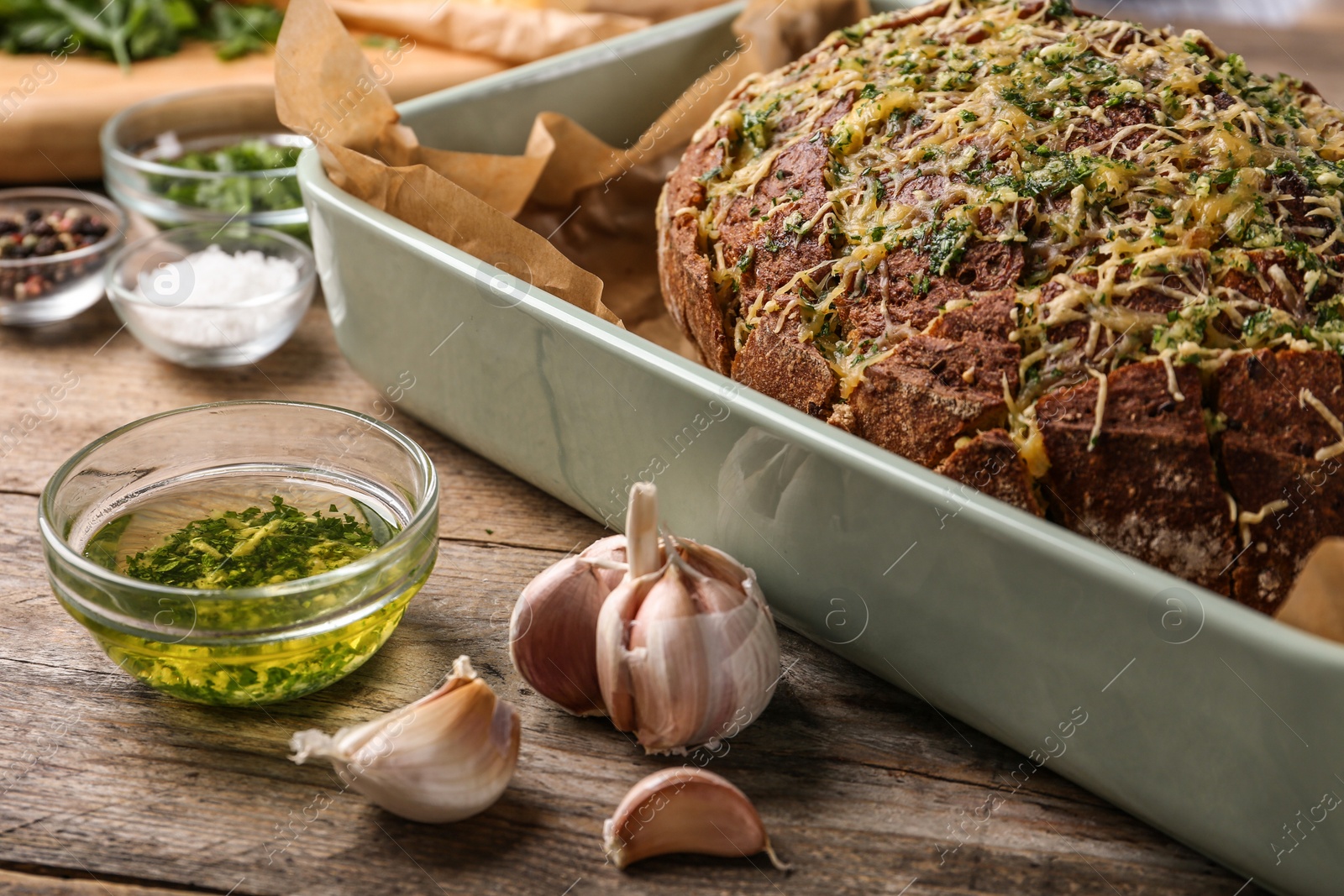 Photo of Tasty homemade garlic bread with cheese and herbs on wooden table