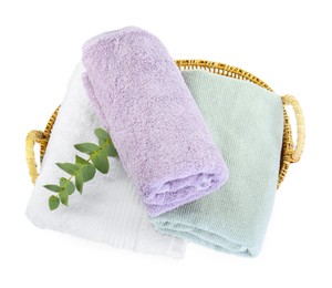 Photo of Basket with different soft towels and eucalyptus branch isolated on white, top view