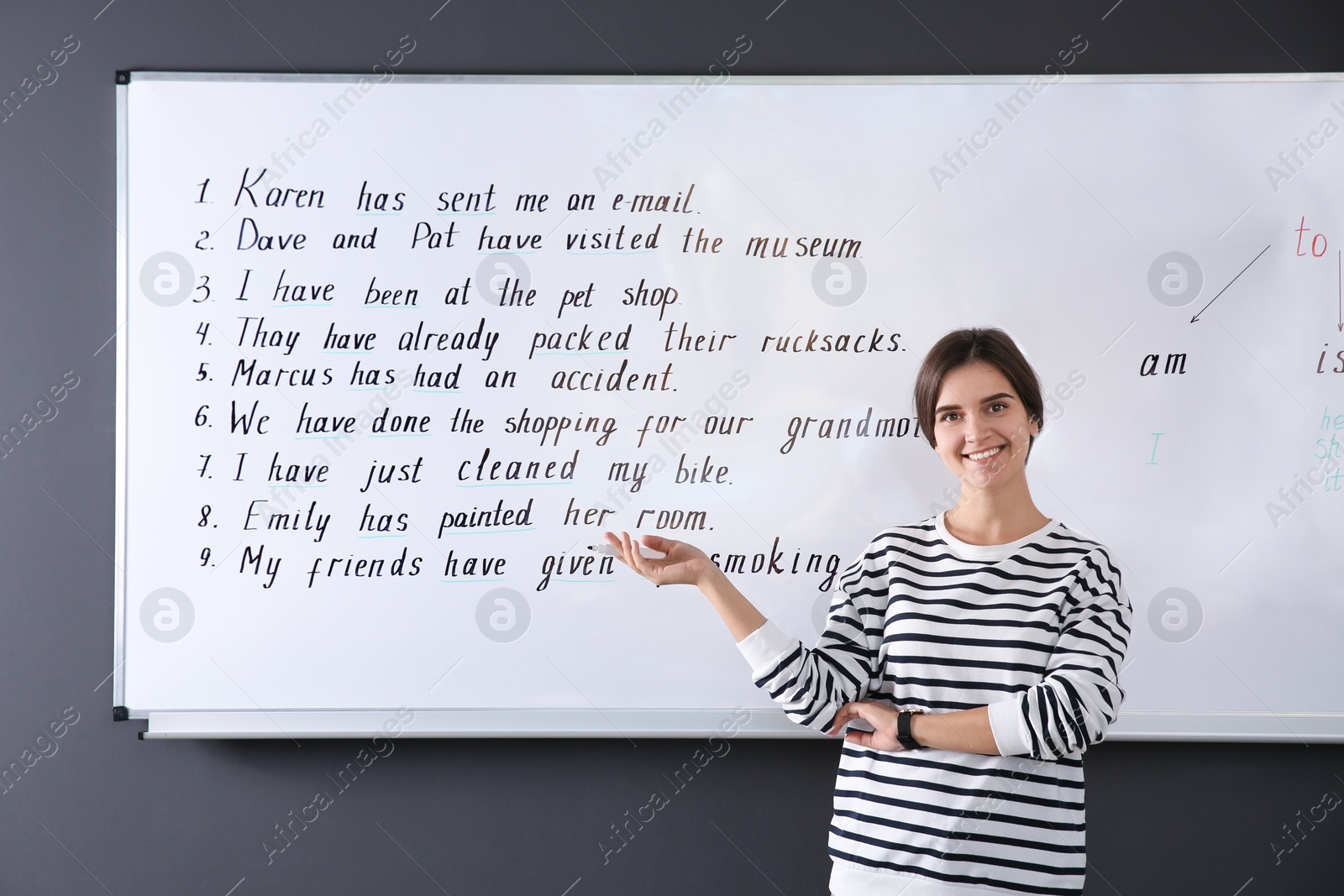 Photo of Happy English teacher near whiteboard at lesson