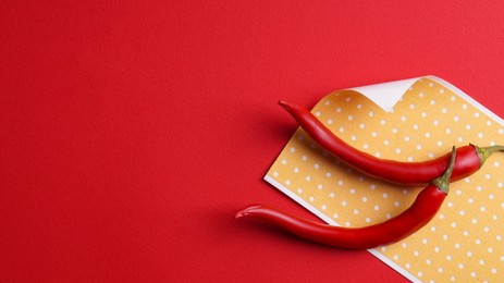 Pepper plasters and chili on red background, flat lay. Space for text