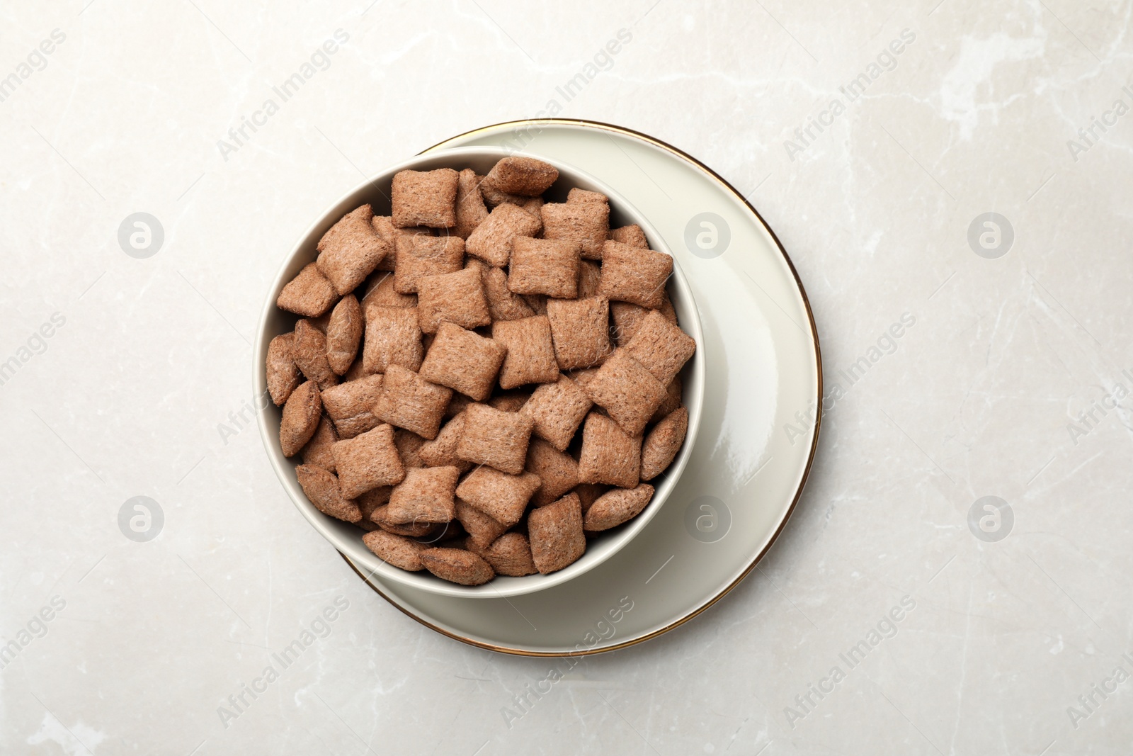 Photo of Sweet crispy corn pads in bowl on light marble table, top view