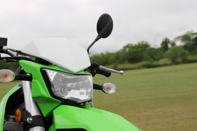 Stylish green cross motorcycle outdoors, closeup view