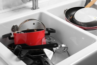 Photo of Messy pile of dirty kitchenware in sink