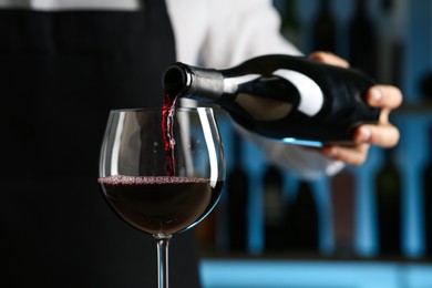 Photo of Bartender pouring wine into glass in restaurant, closeup