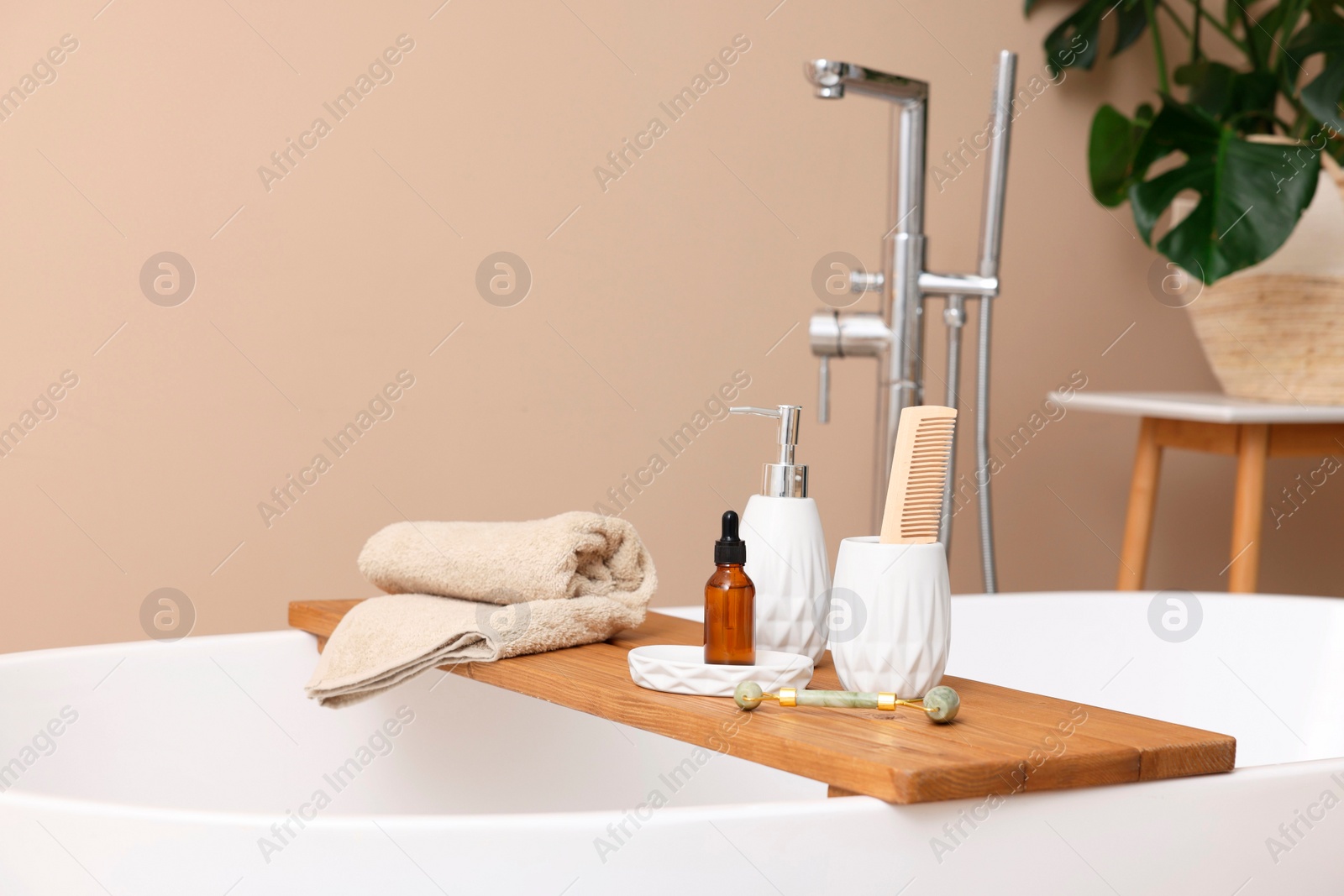 Photo of Different personal care products and accessories on bath tub in bathroom