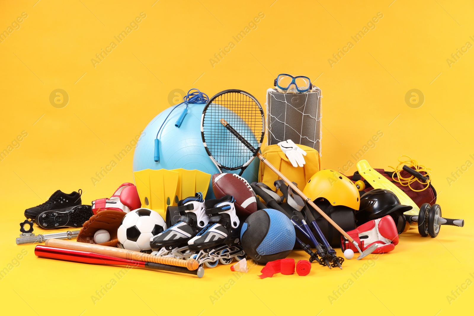 Photo of Many different sports equipment on yellow background