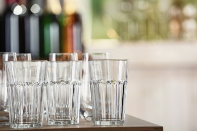 Empty glasses on wooden table against blurred background