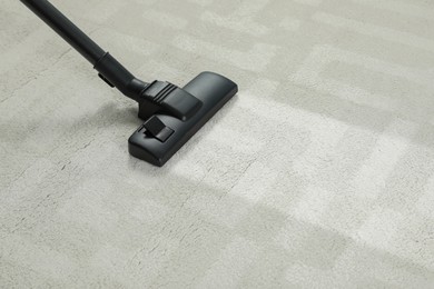 Hoovering carpet with vacuum cleaner, space for text. Clean trace on dirty surface