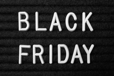 Photo of Words Black Friday on dark fabric, flat lay