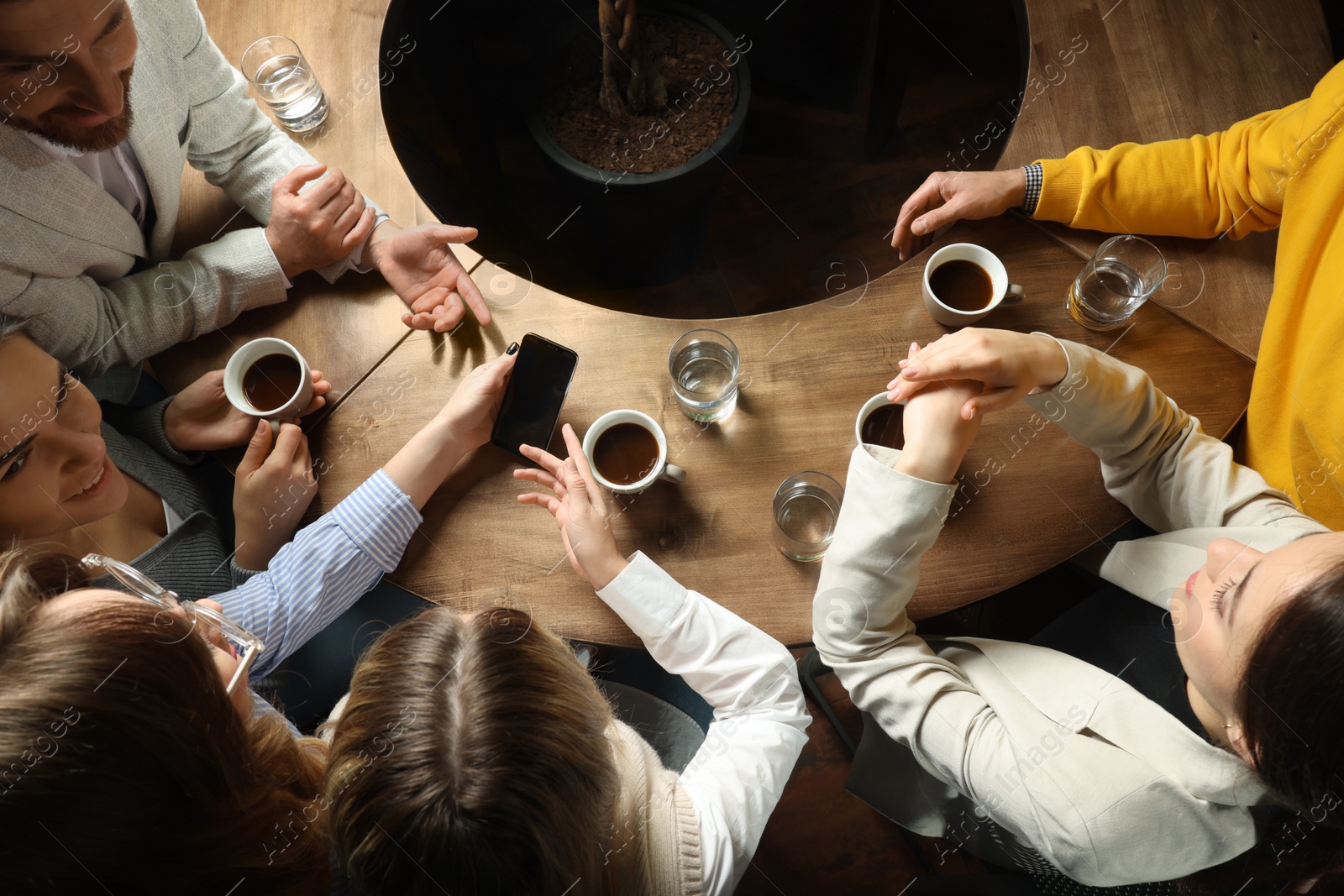 Photo of Friends with coffee spending time together in cafe, above view