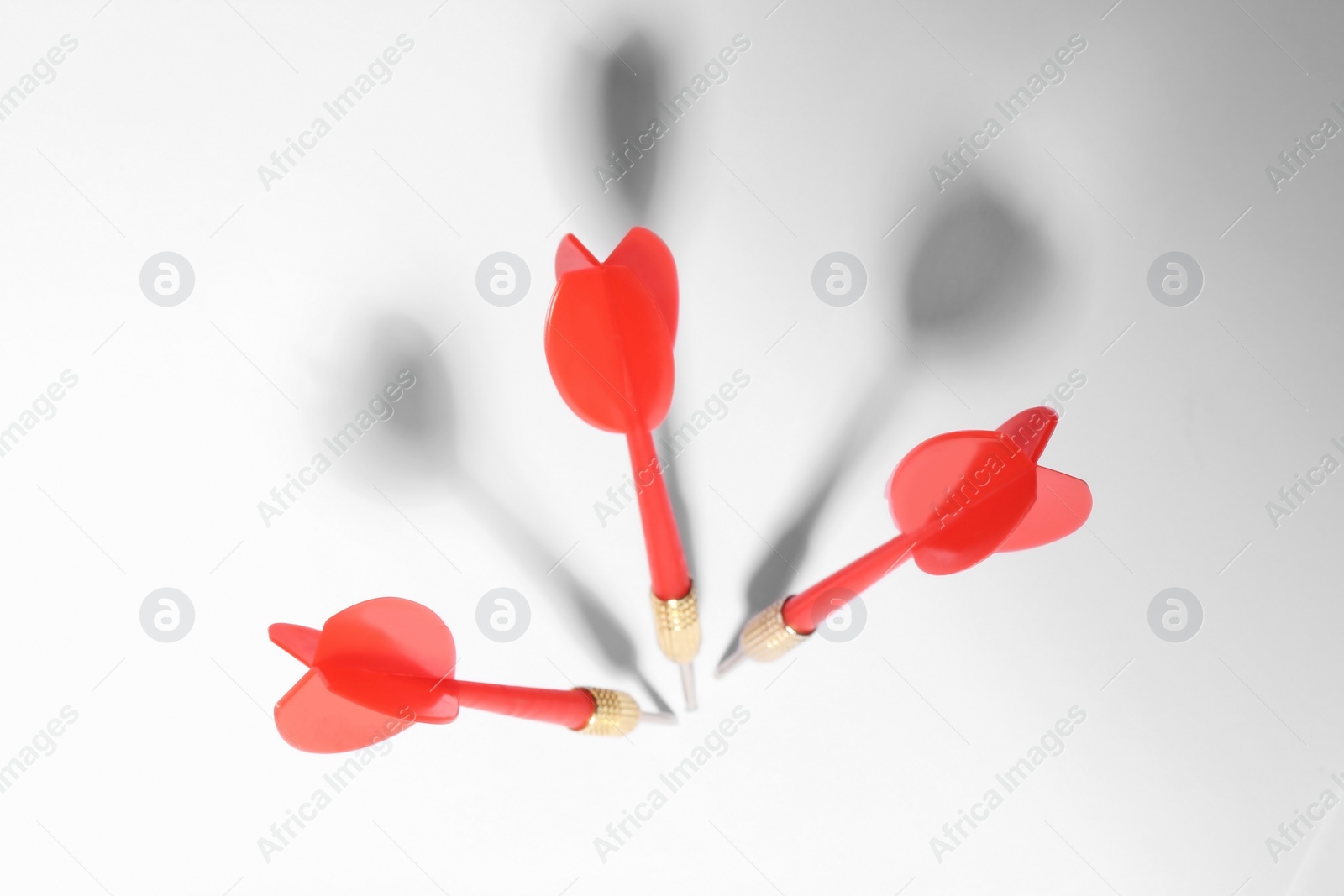 Photo of Red dart arrows for game on white background, above view