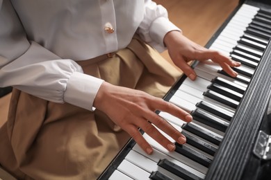 Photo of Young woman playing piano, closeup. Music lesson