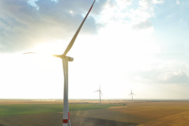 Photo of Modern windmill in field, space for text. Energy efficiency