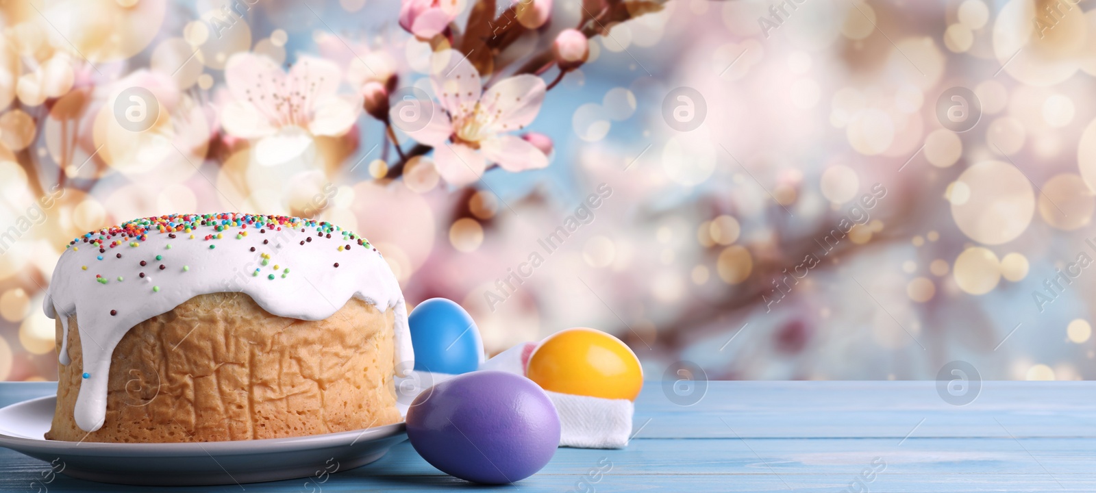 Image of Traditional Easter cake and eggs on wooden table outdoors, space for text. Banner design