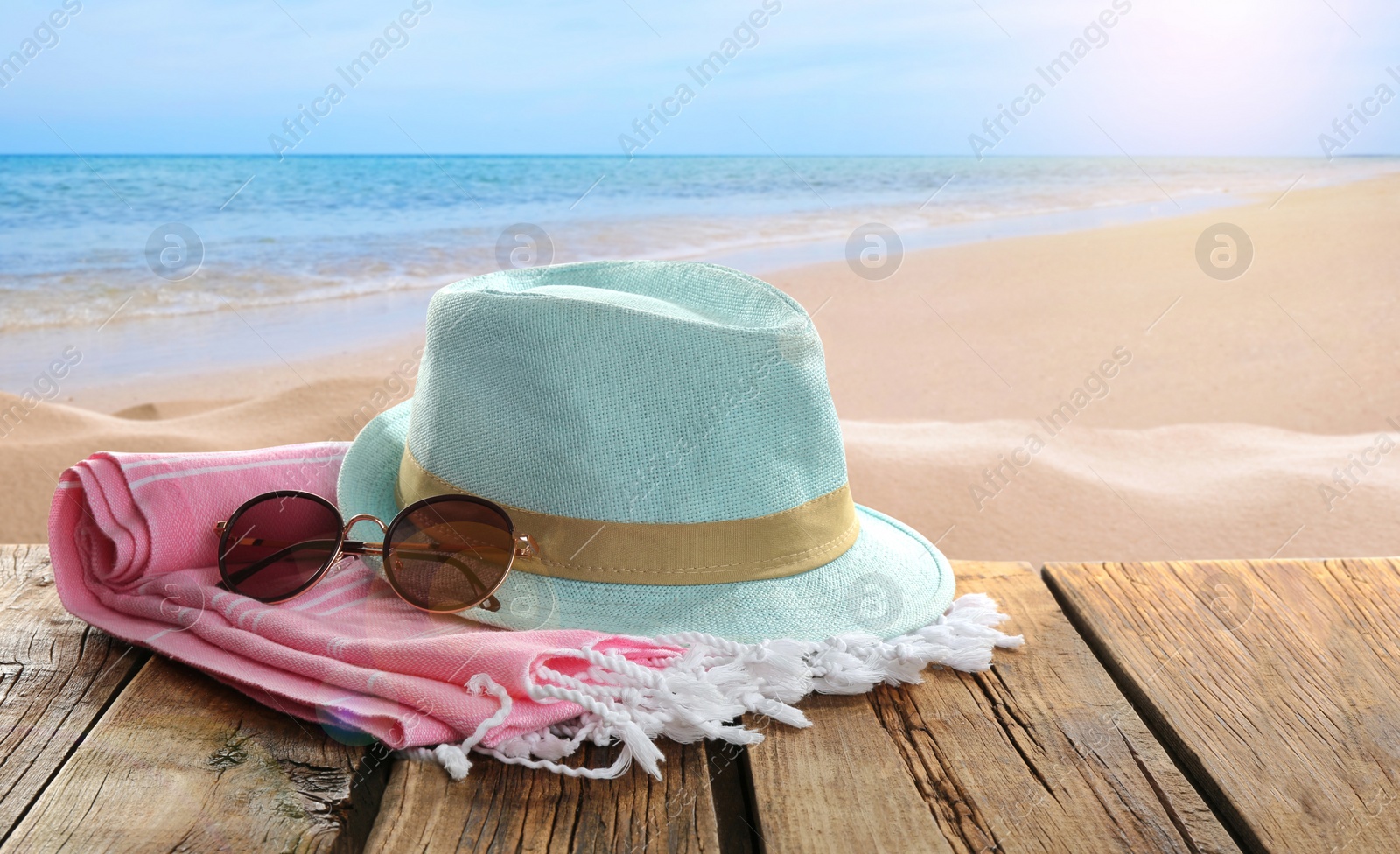 Image of Beach accessories on wooden surface near ocean 