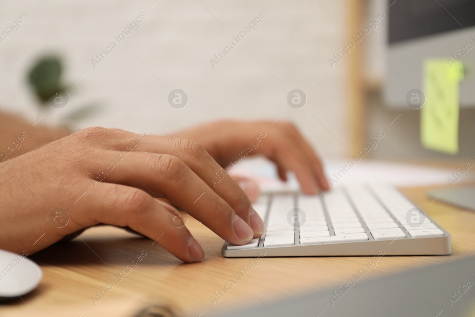 Photo of Man using computer at table in office, closeup