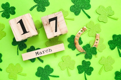 Photo of Flat lay composition with block calendar on light green background. Saint Patrick's Day celebration