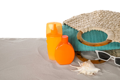 Photo of Composition with sun protection products on sand against white background