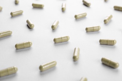 Photo of Many vitamin capsules on white background, closeup