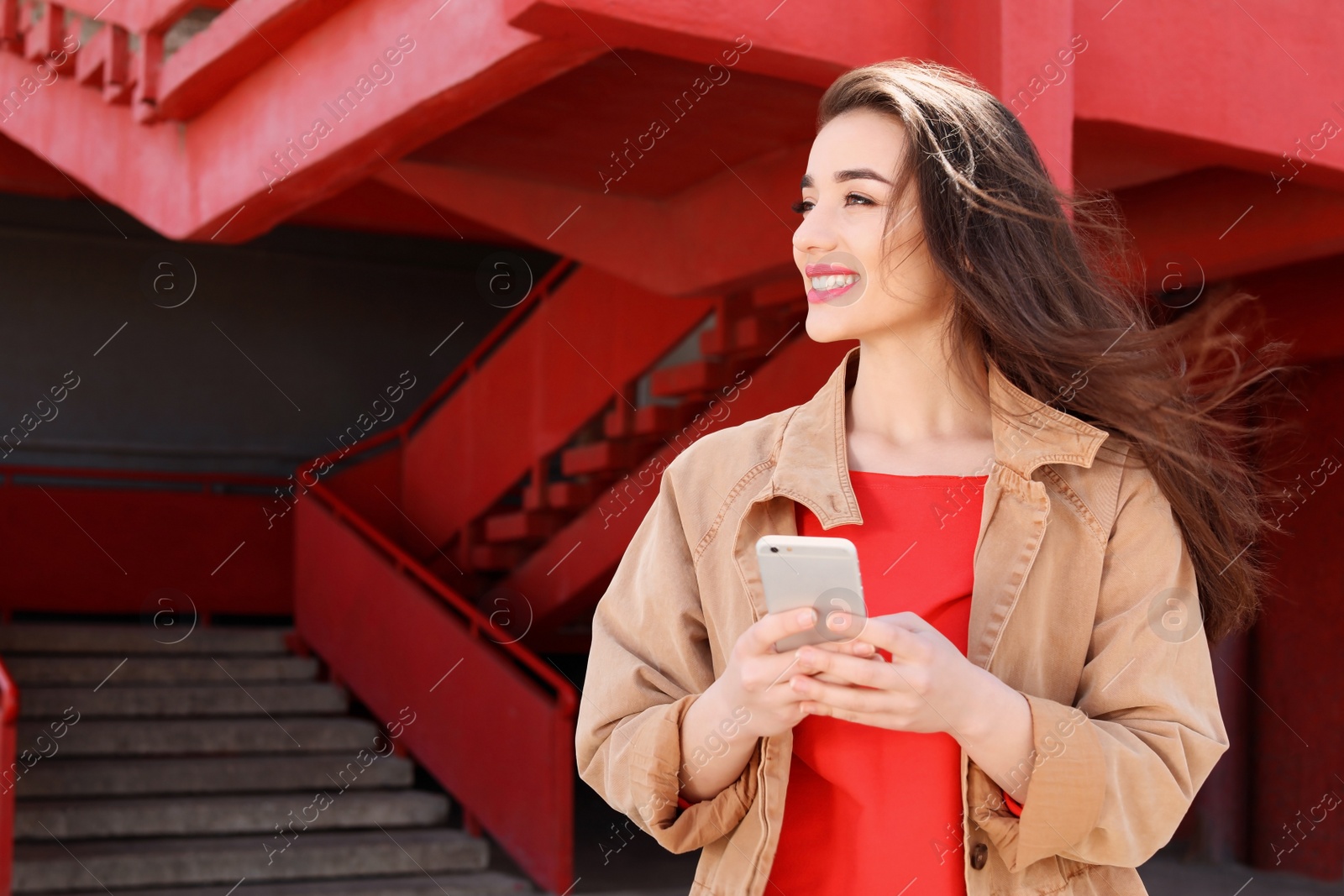 Photo of Young woman using mobile phone outdoors