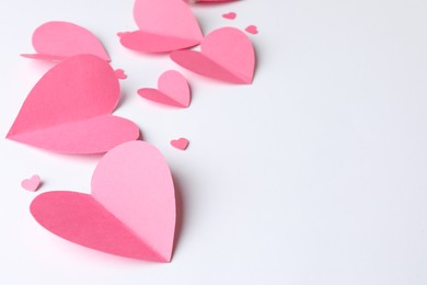 Photo of Pink paper hearts on white background. Space for text