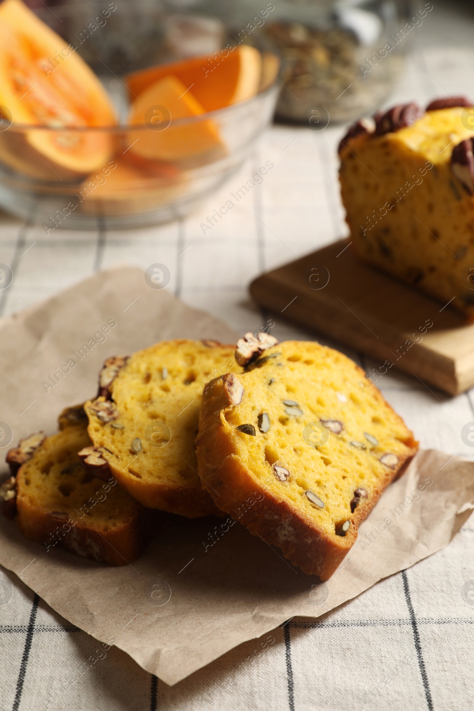 Photo of Delicious pumpkin bread with pecan nuts on tablecloth