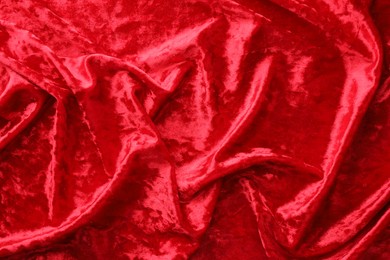 Photo of Texture of crumpled red velvet fabric as background, top view