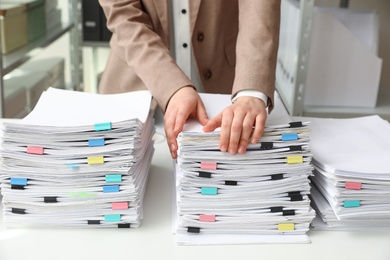 Woman working with documents at table in office, closeup