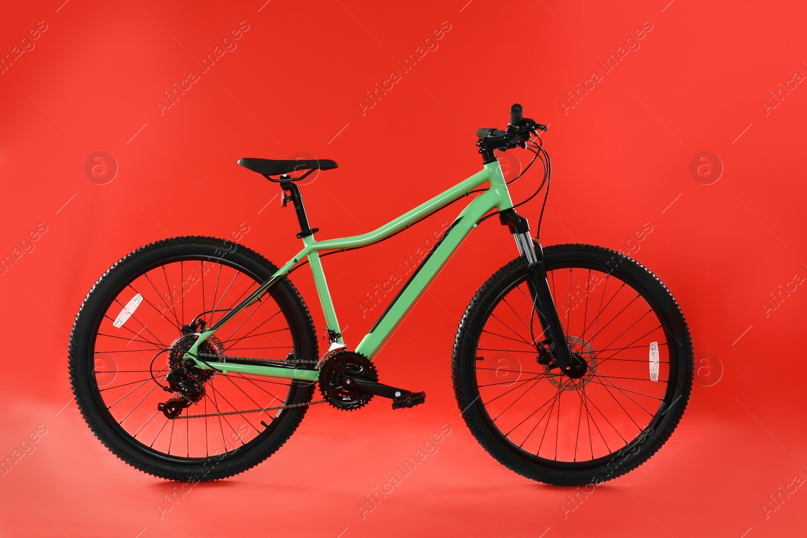 Photo of Modern bicycle on red background. Healthy lifestyle