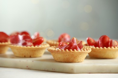 Delicious canapes with jamon on white table, closeup