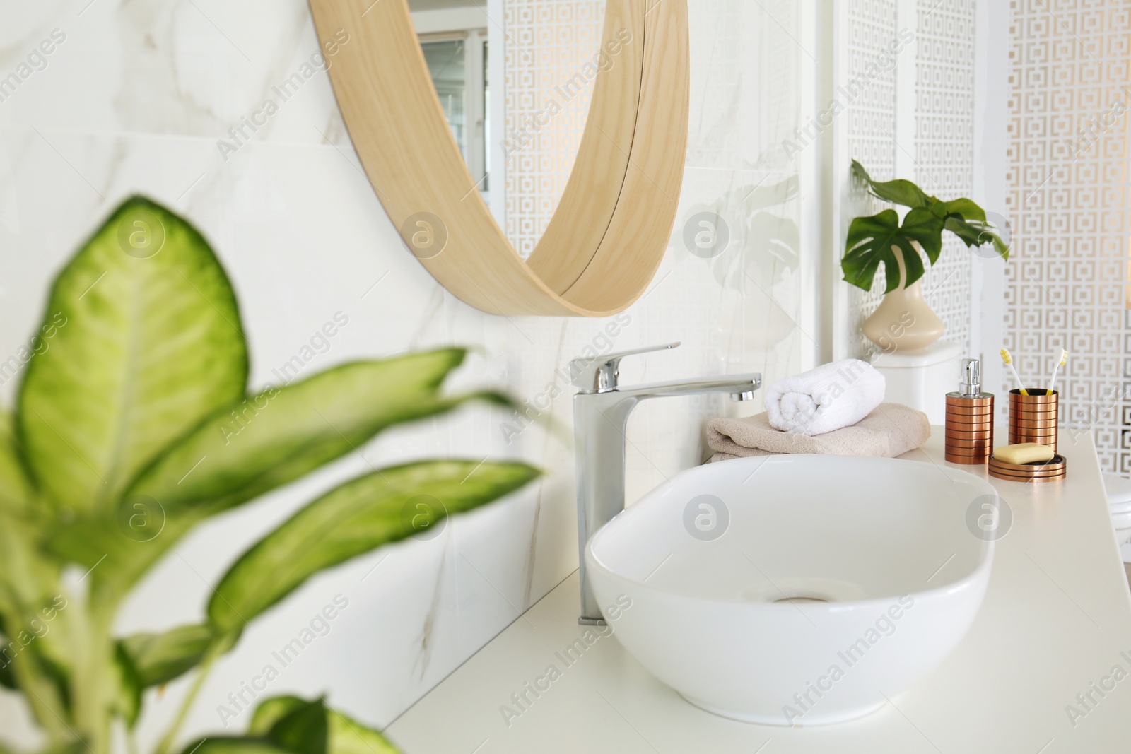 Photo of Round mirror over sink in stylish bathroom