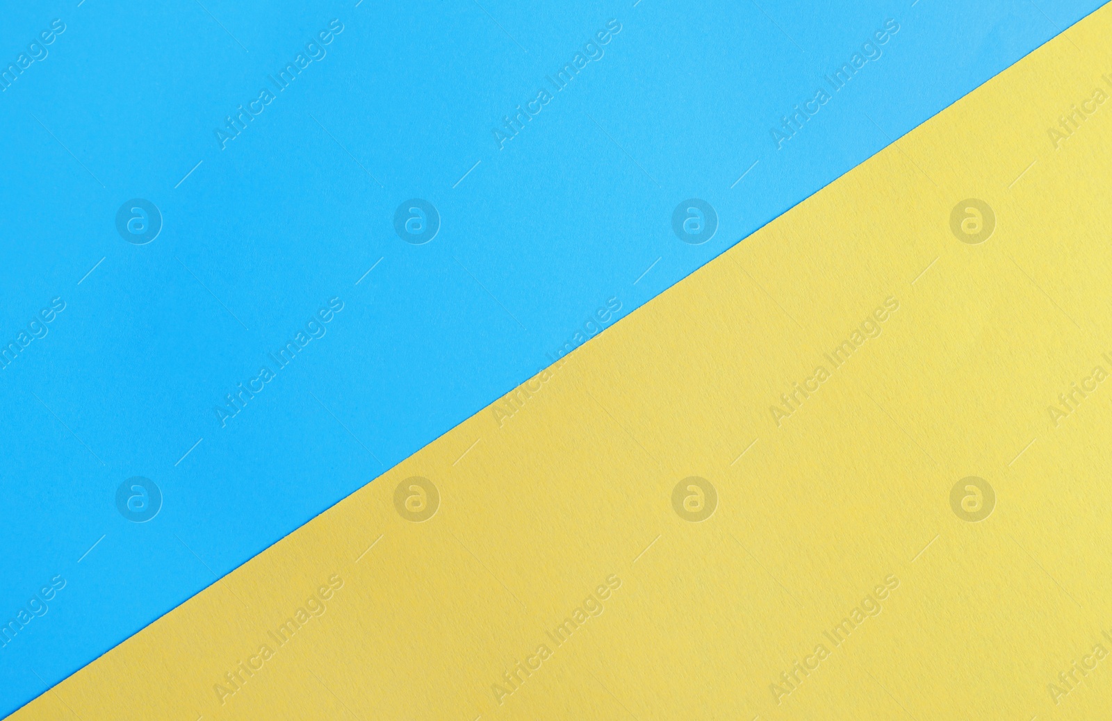 Photo of Blue and yellow paper sheets as colorful background, top view