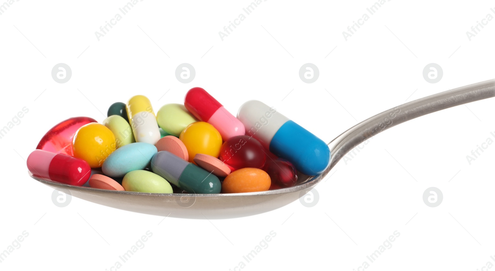 Photo of Different colorful pills in spoon isolated on white