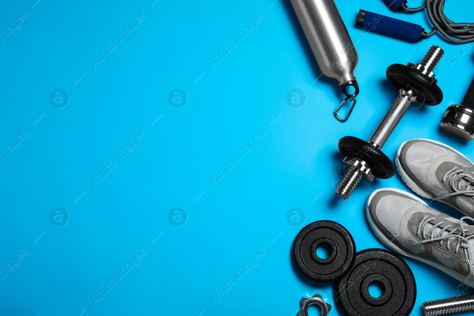 Gym equipment on light blue background, flat lay. Space for text Photo of Gym equipment on light blue background, flat lay. Space for text