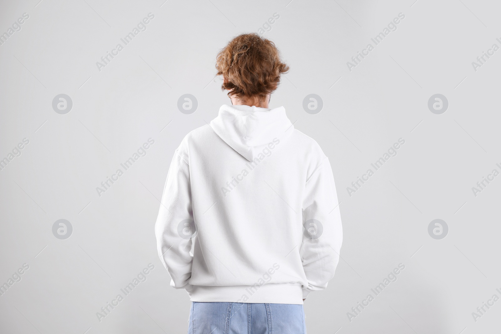 Photo of Man in hoodie sweater on light background. Space for design