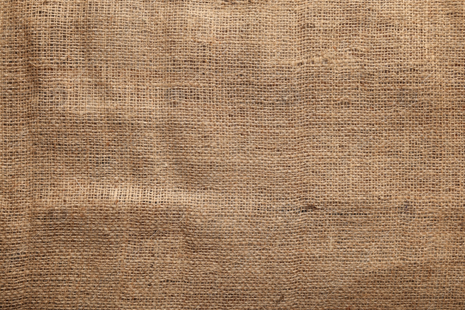 Photo of Texture of natural burlap fabric as background, top view