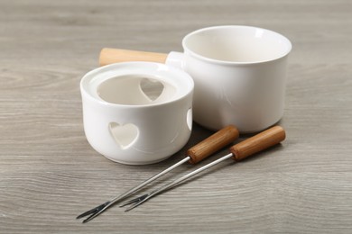 Photo of Fondue set on wooden table. Kitchen equipment