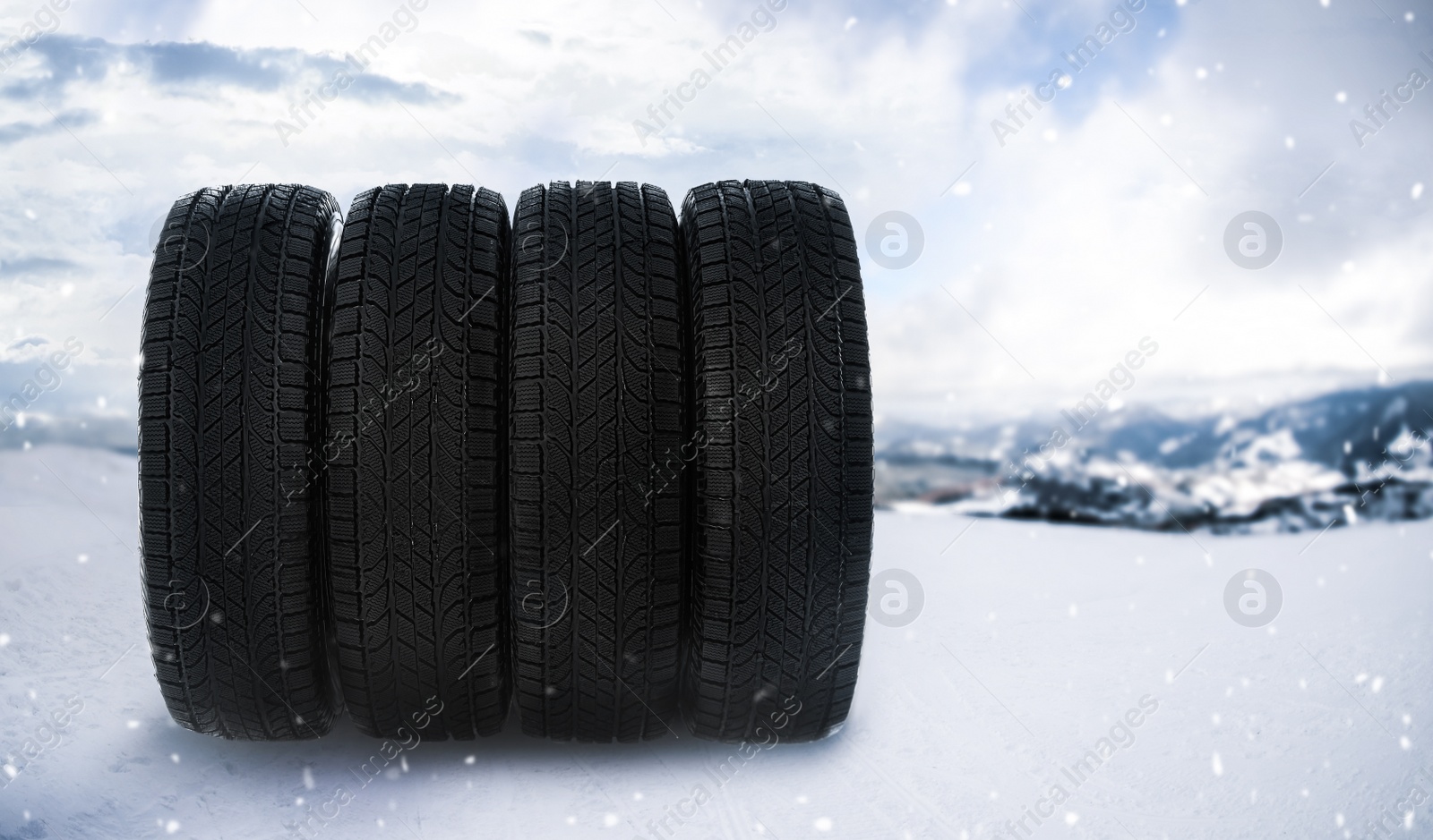 Image of Set of new winter tires outdoors on snow 