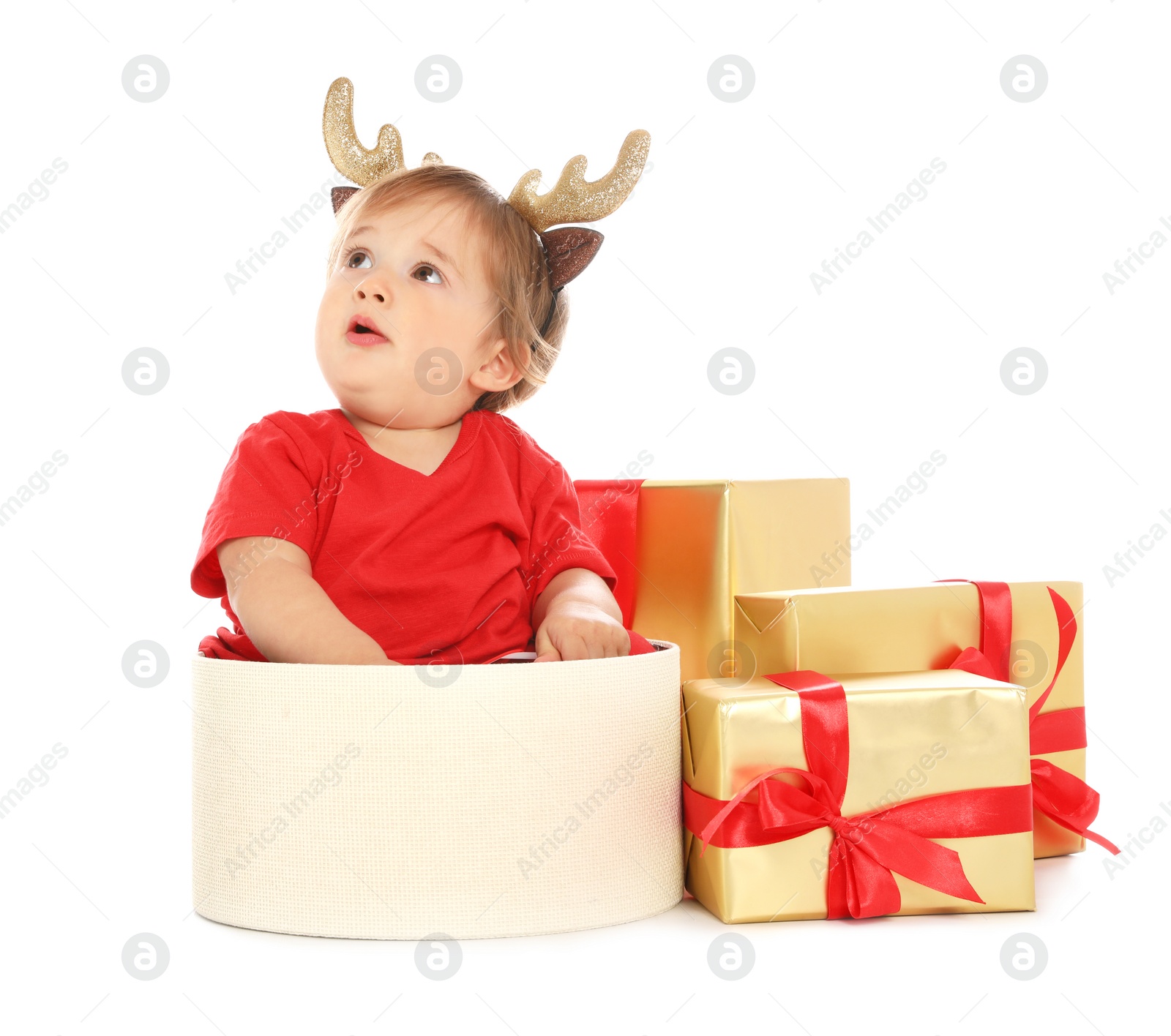 Photo of Festively dressed baby with Christmas gifts on white background