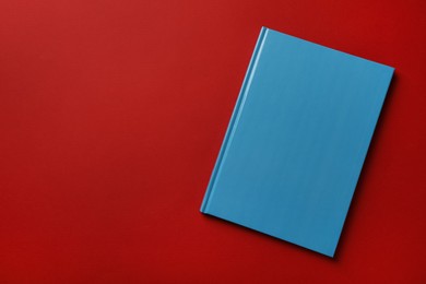 Photo of New stylish planner with hard cover on red background, top view. Space for text