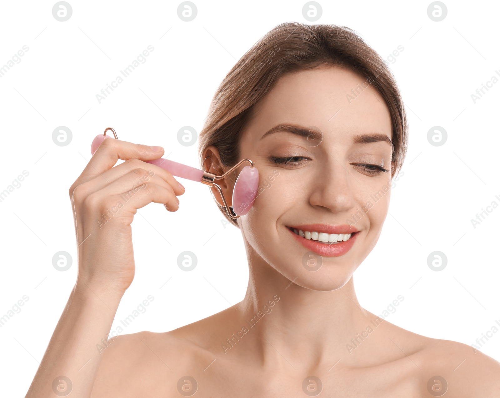 Photo of Young woman using natural rose quartz face roller on white background