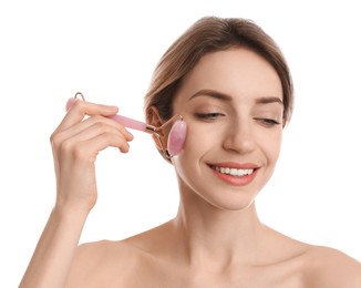 Photo of Young woman using natural rose quartz face roller on white background