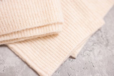 Photo of Soft folded sweater on grey table, above view