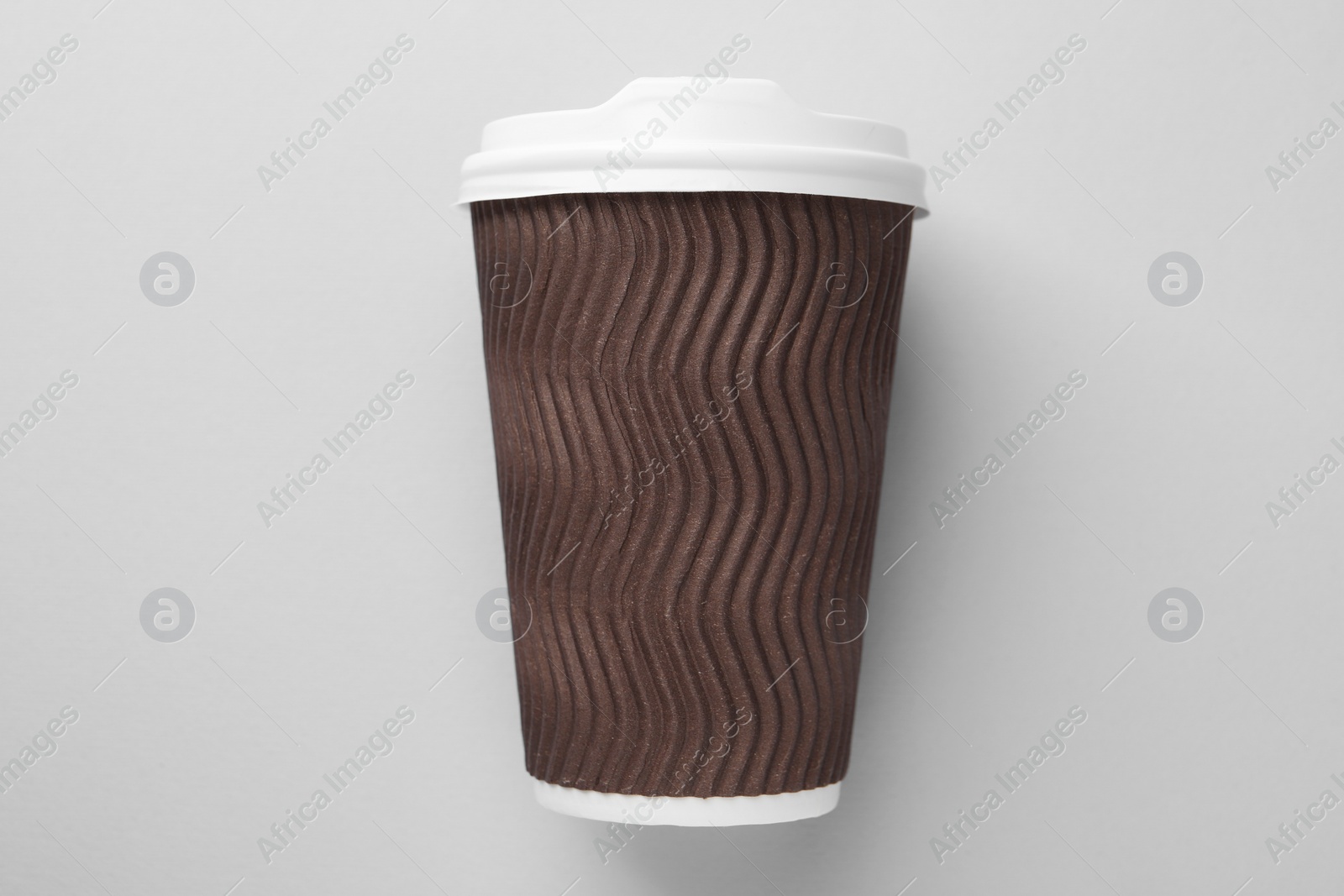 Photo of One paper cup on light grey background, top view. Coffee to go