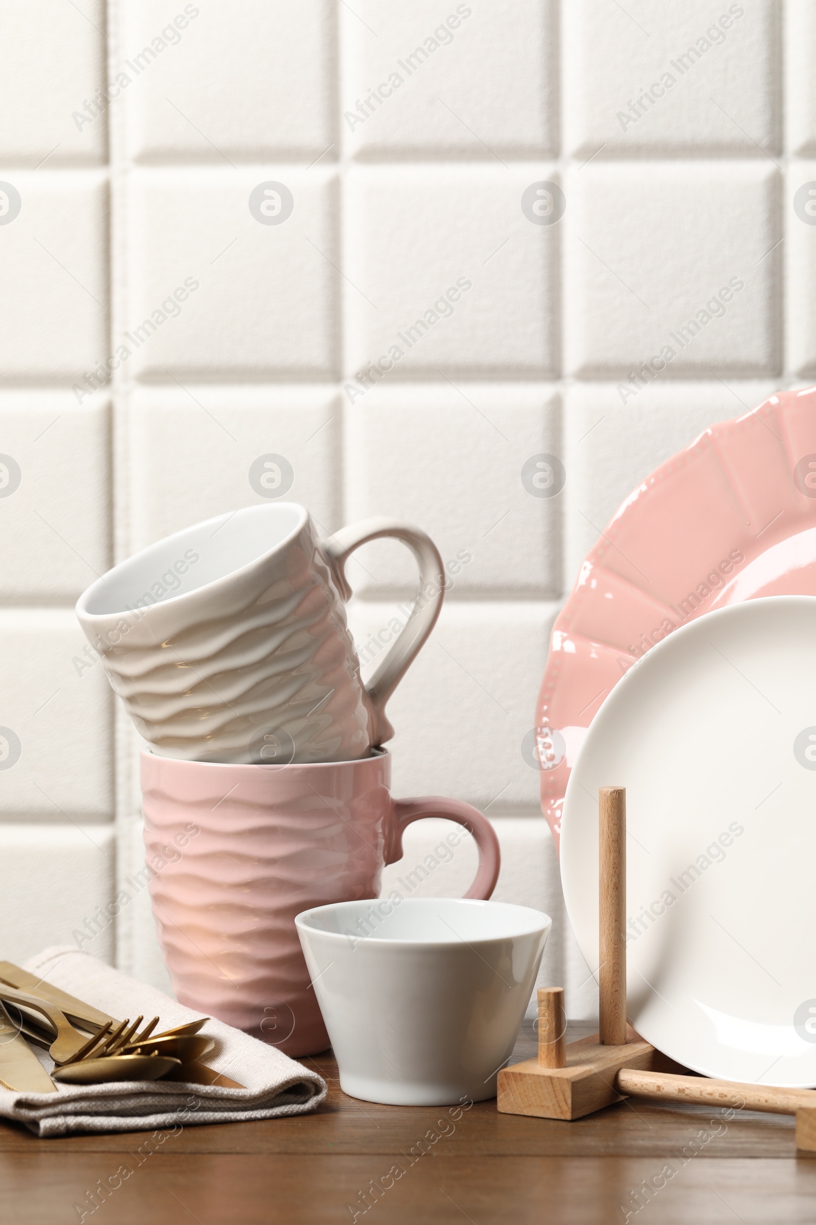 Photo of Beautiful ceramic dishware, cups and cutlery on wooden table