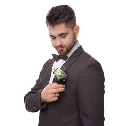 Photo of Handsome young groom with boutonniere on white background. Wedding accessory