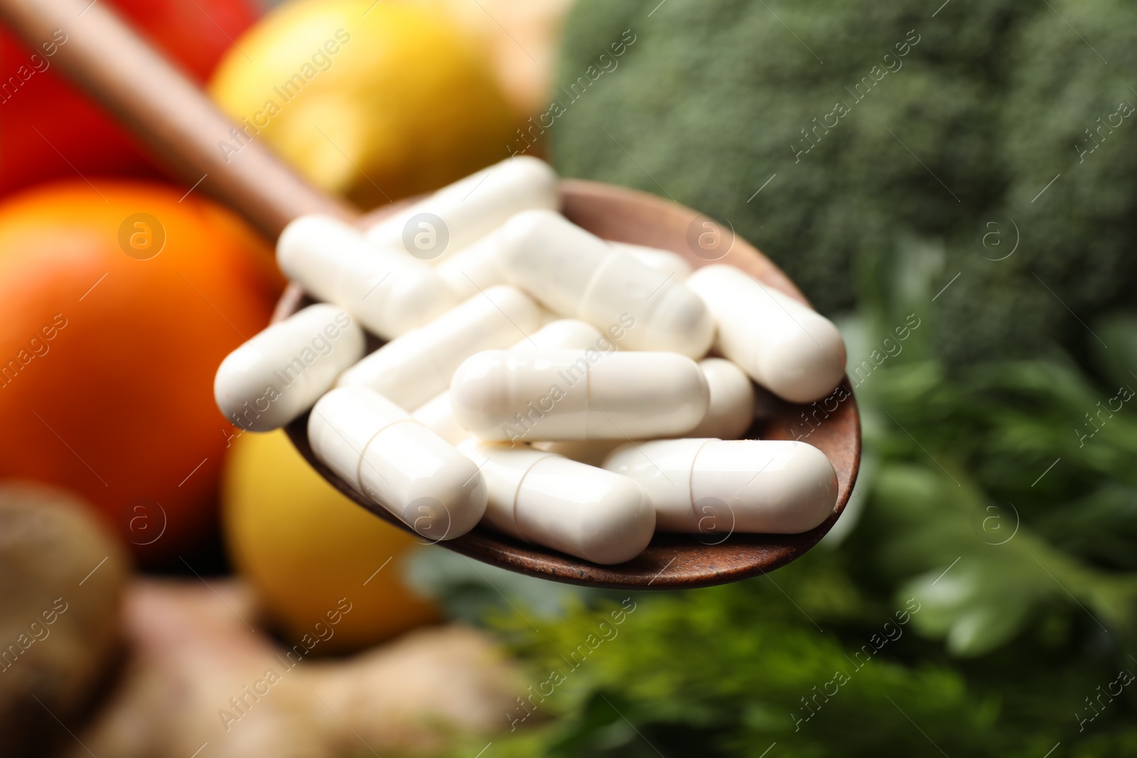 Photo of Dietary supplements. Spoon with pills over food products, closeup