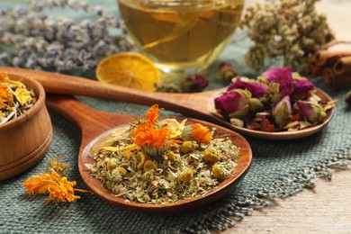 Mix of dried herbs and tea on table, closeup view