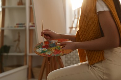 Young woman drawing on easel at home, closeup